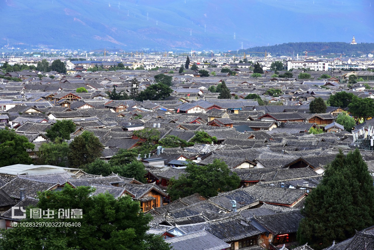 中國云南省麗江市麗江古城,傍晚,古城全景,夕陽西下,納西族建筑的屋頂和遠山,映在太陽光下。